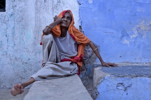 Vieille femme assise devant chez elle