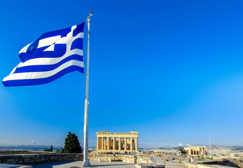 Parthenon temple on the Acropolis in Athens, Greece with Greek flag.