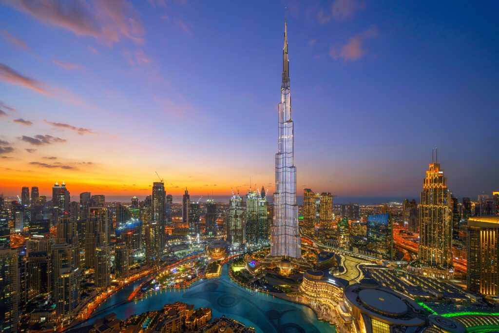 Aerial view of Burj Khalifa in Dubai Downtown skyline and fountain, United Arab Emirates or UAE. Financial district and business area in smart urban city. Skyscraper and high-rise buildings at night.