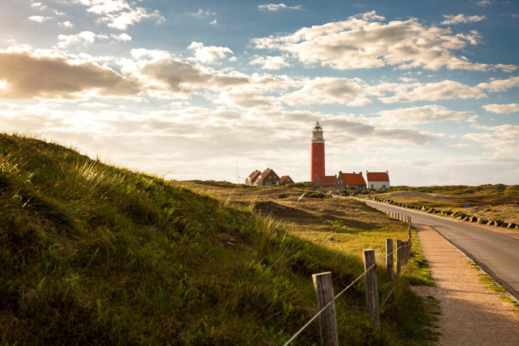 Iconic lighthouse surrounded by houses during sunset at the island of Texel, The Netherlands