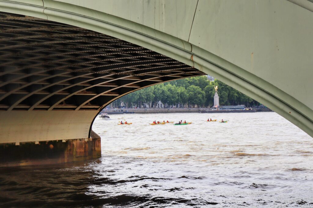 Group of people kayaking on London Thames River next to the Westminster Bridge