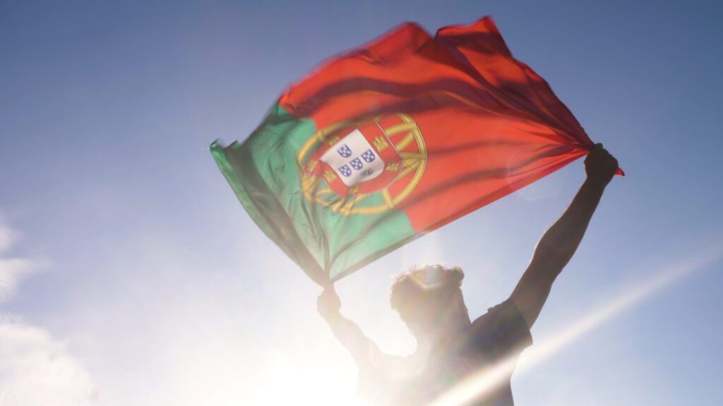 Jeune homme porte le drapeau du portugal pour le foot
