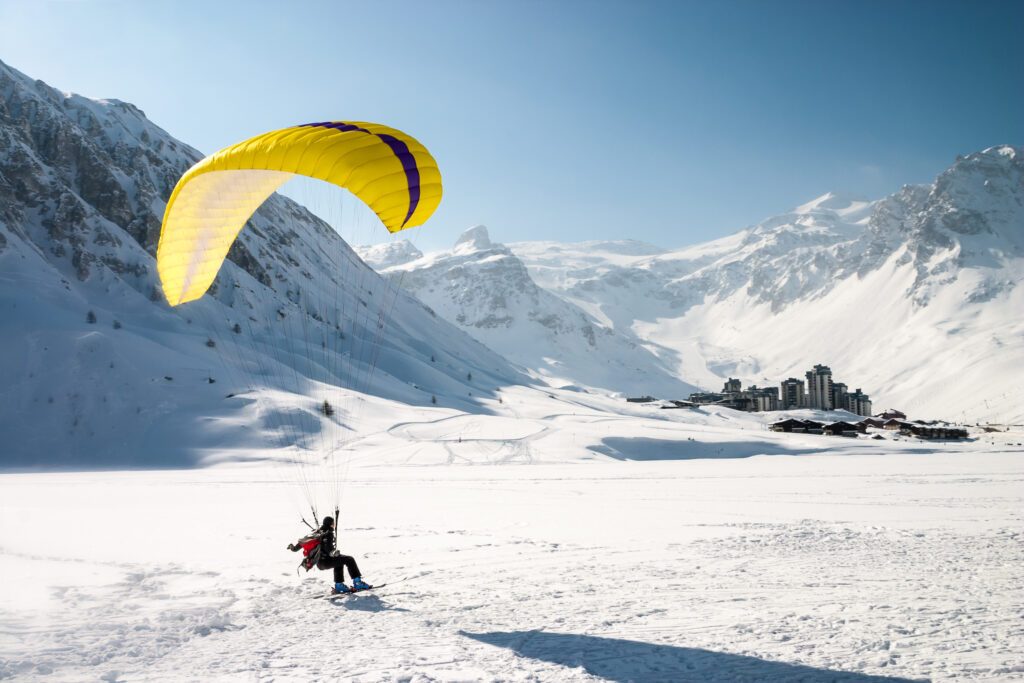 Paraglider landing on skis in Tignes, French Alps