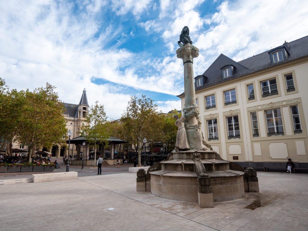 The Place d'Armes is a square in Luxembourg City in the south of the Grand Duchy of Luxembourg. Dicks-Lentz monument in the foreground. Cloudy sky.