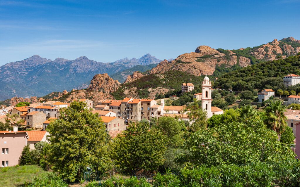 View of Piana village with church tower in mountain landscape of western Corsica, France