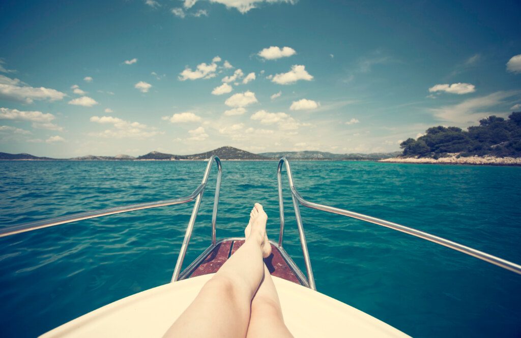 Woman feet closeup, sea in the background - girl relaxing on a y