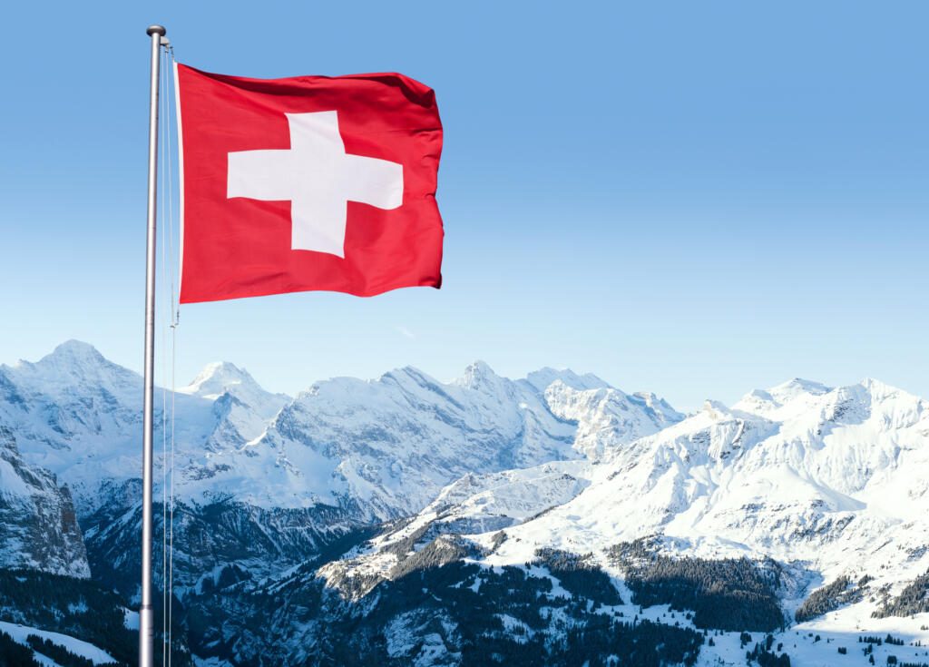 Drapeau suisse flottant face au paysage alpin
