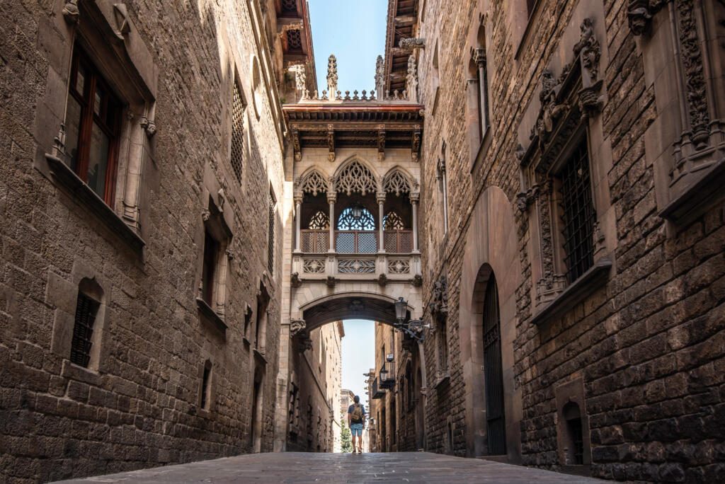 A male traveler with a backpack visiting the Gothic quarter of the city of Barcelona, Spain