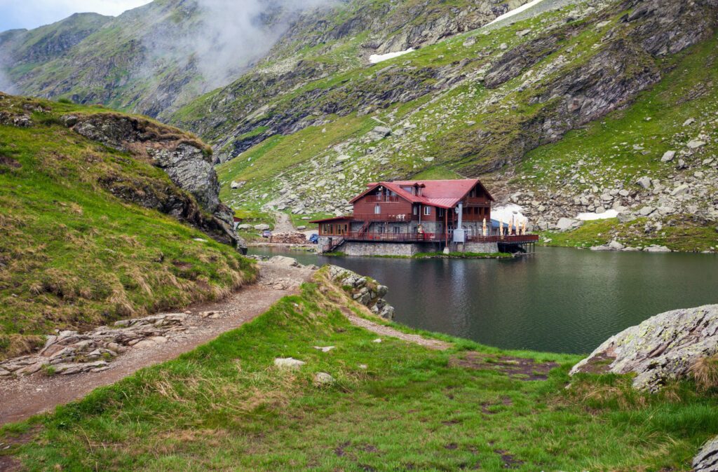 Idyllic view with typical lodge on Balea Lake shore in Fagaras M