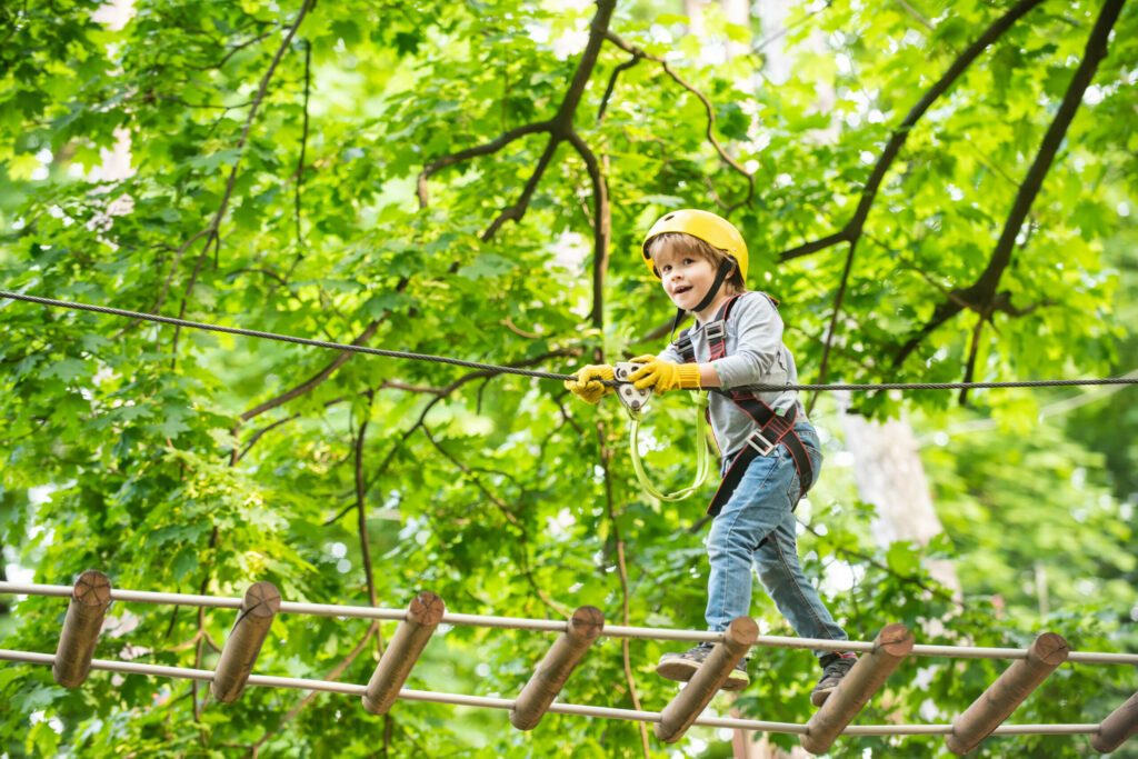 Rope park - climbing center. Child boy having fun at adventure park. Go Ape Adventure. Child boy having fun at adventure park