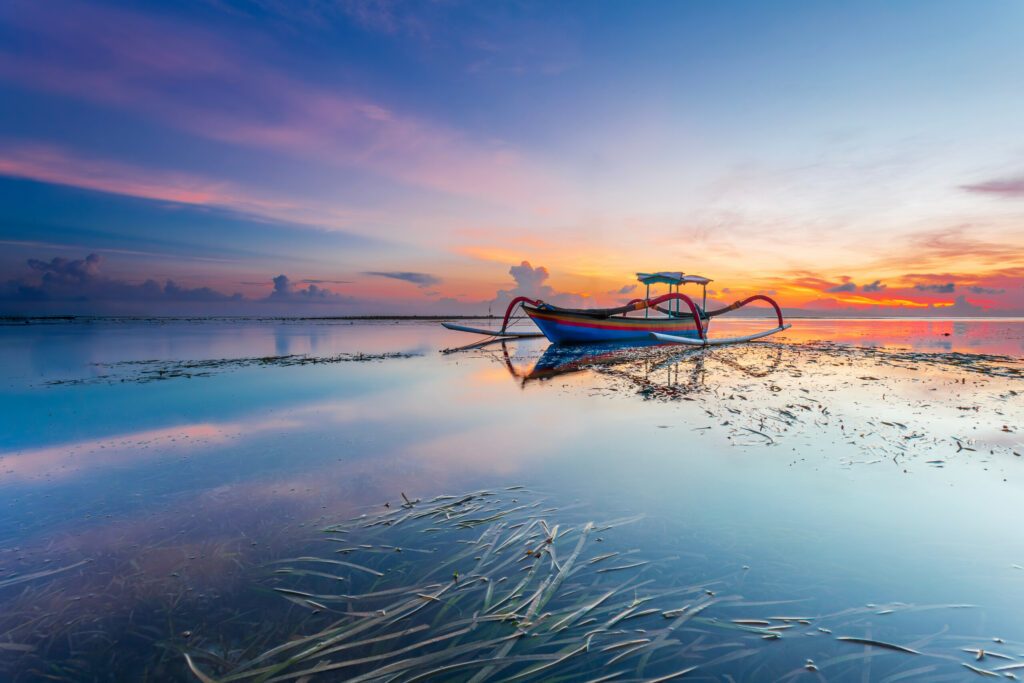 Morning sun in Bali, Indonesia. Traditional fishing boats at Sanur beach, Bali, Indonesia.