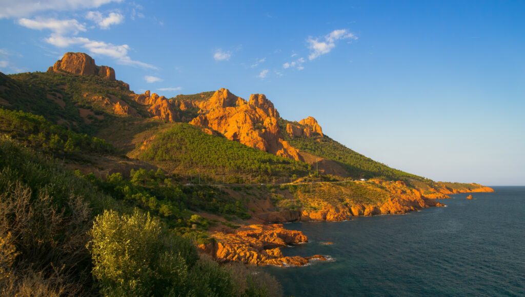 Red and orange volcanic cliffs and hills between Agay and Cannes in the Esterel massif.