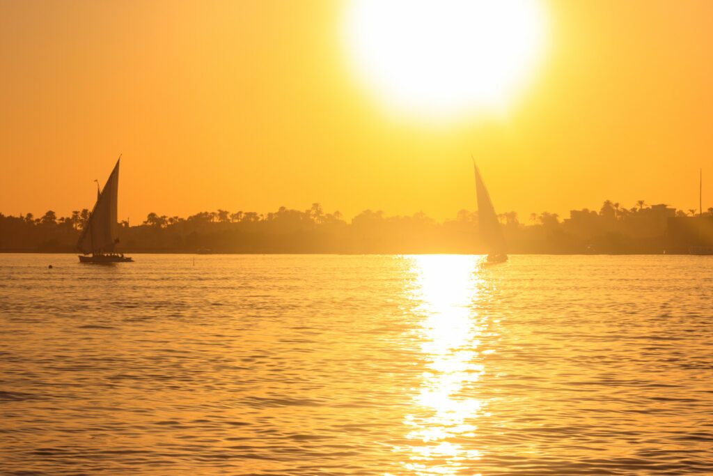 View of the Nile river with sailboats at sunset in Luxor, Egypt