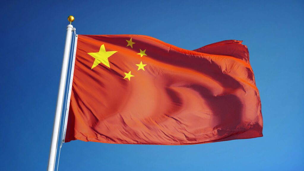 China flag waving against clean blue sky, close up, isolated with clipping path mask alpha channel transparency