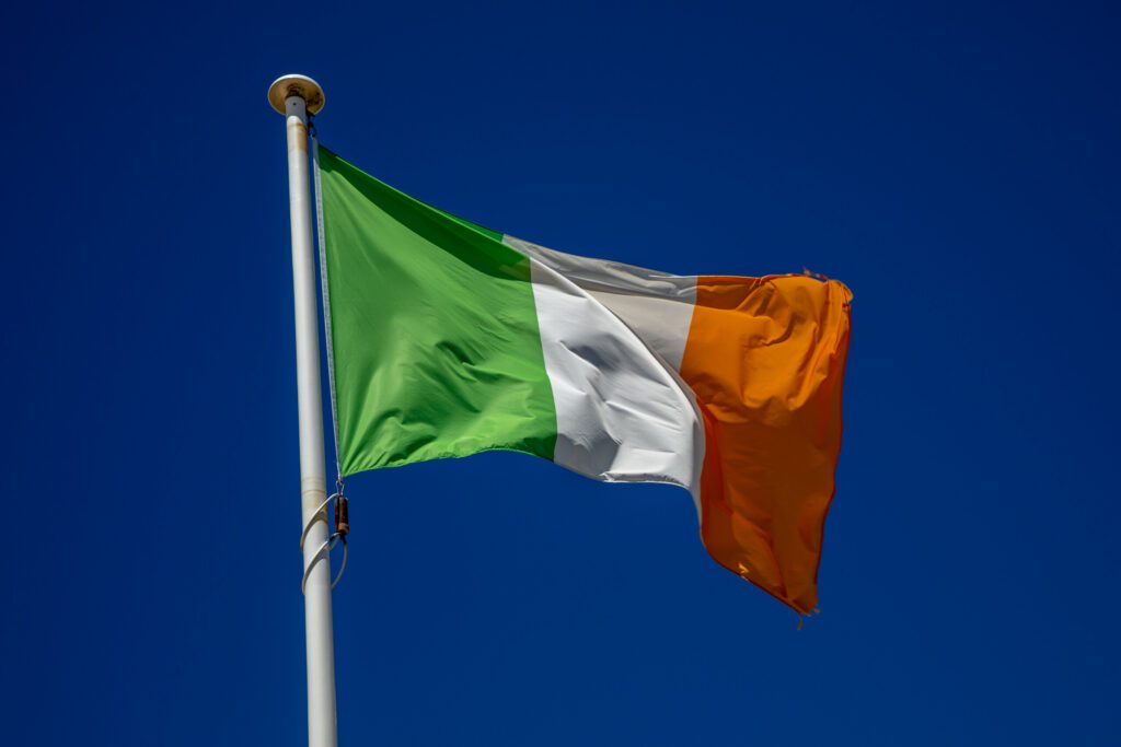 irish flag ireland country flag on top of the mast in the wind and blue sky