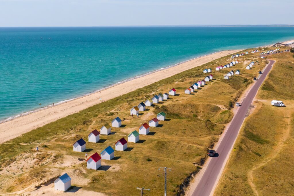 Colourful beach huts, wooden beach cabins in Gouville-sur-Mer, Normandy, France.