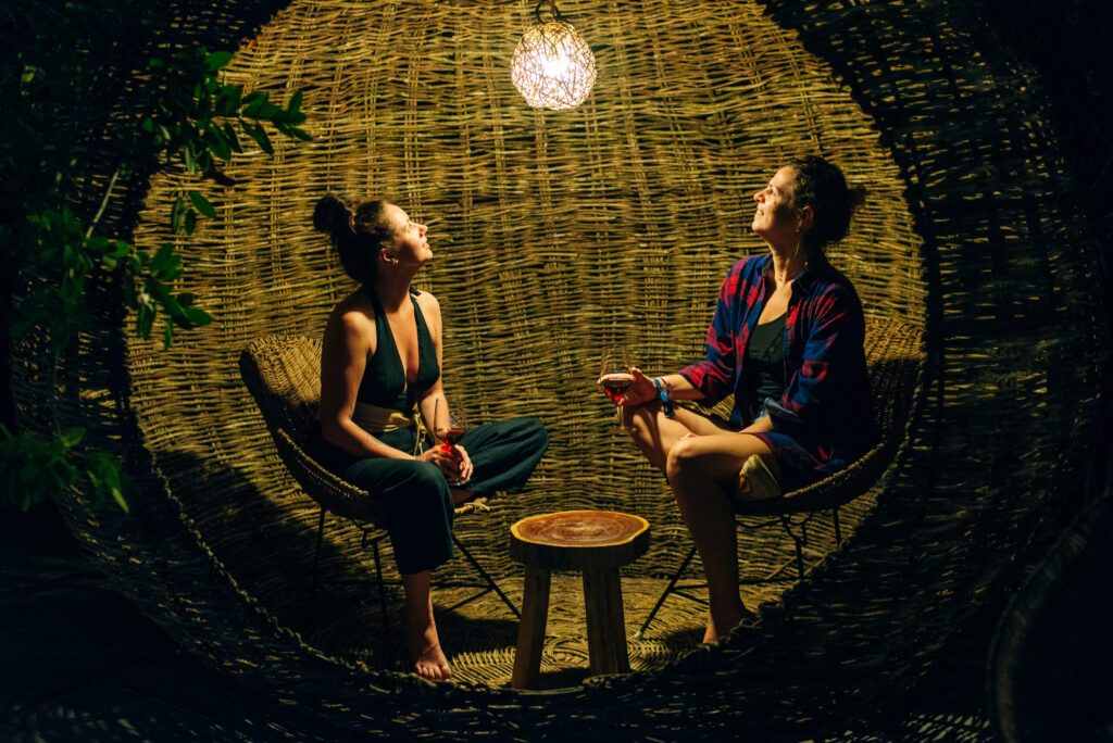 girls drink wine in Rattan lounge at night, mexico, tulum