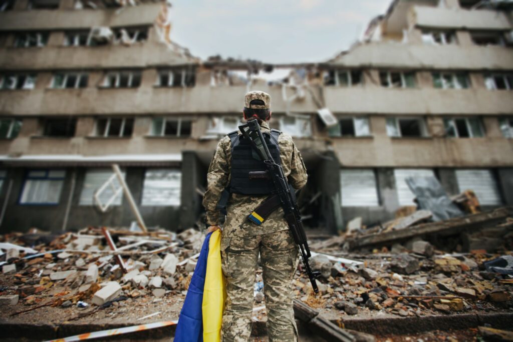 Militaire devant une maison détruite par la guerre