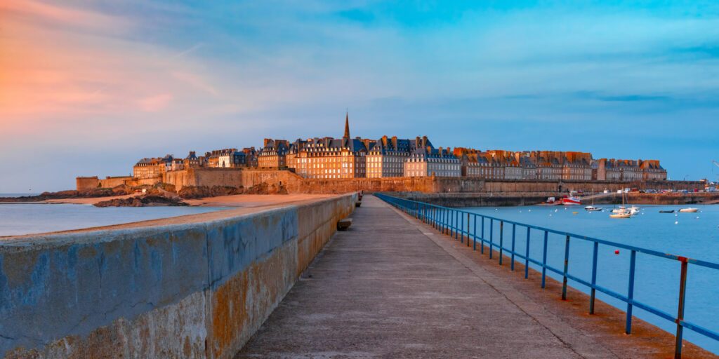 Panoramic view of walled city Saint-Malo with St Vincent Cathedral at sunset. Saint-Maol is famous port city of Privateers is known as city corsaire, Brittany, France