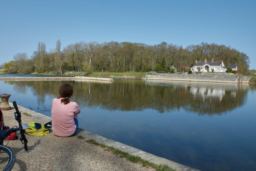 femme cycliste se reposant au bord du cher