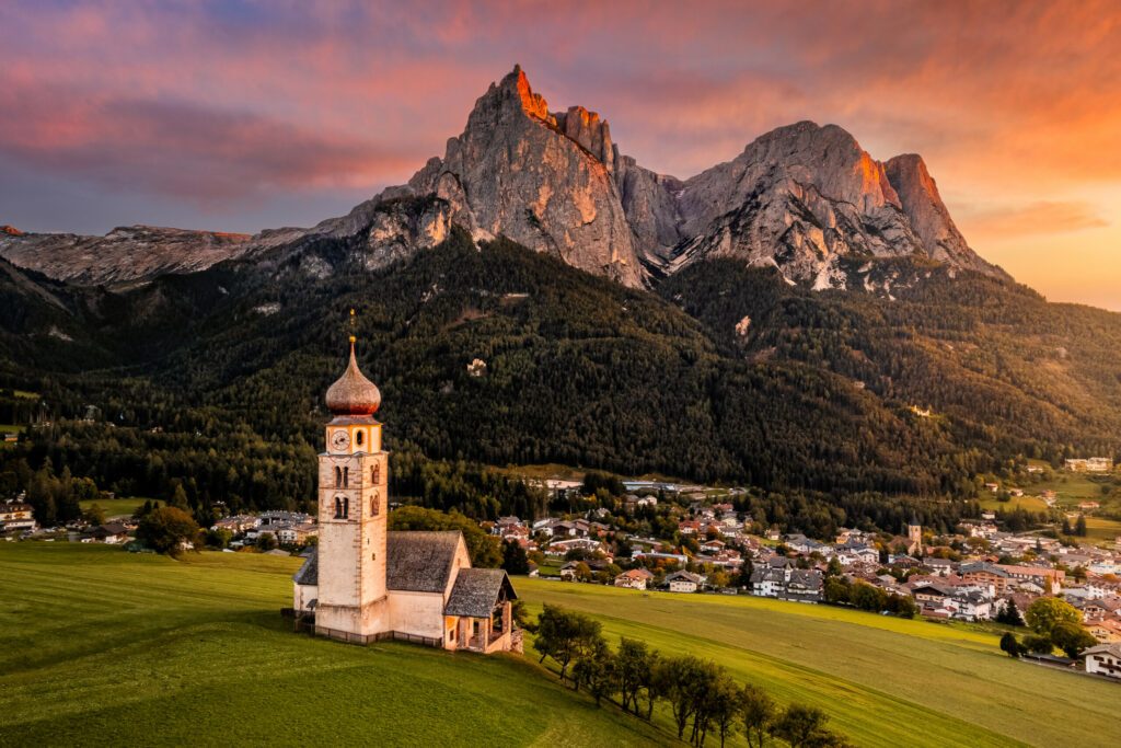 Seis am Schlern, Italy - Beautiful sunset and aerial mountain scenery in the Italian Dolomites with St. Valentin Church and famous Mount Sciliar with colorful clouds and warm sunlight at South Tyrol
