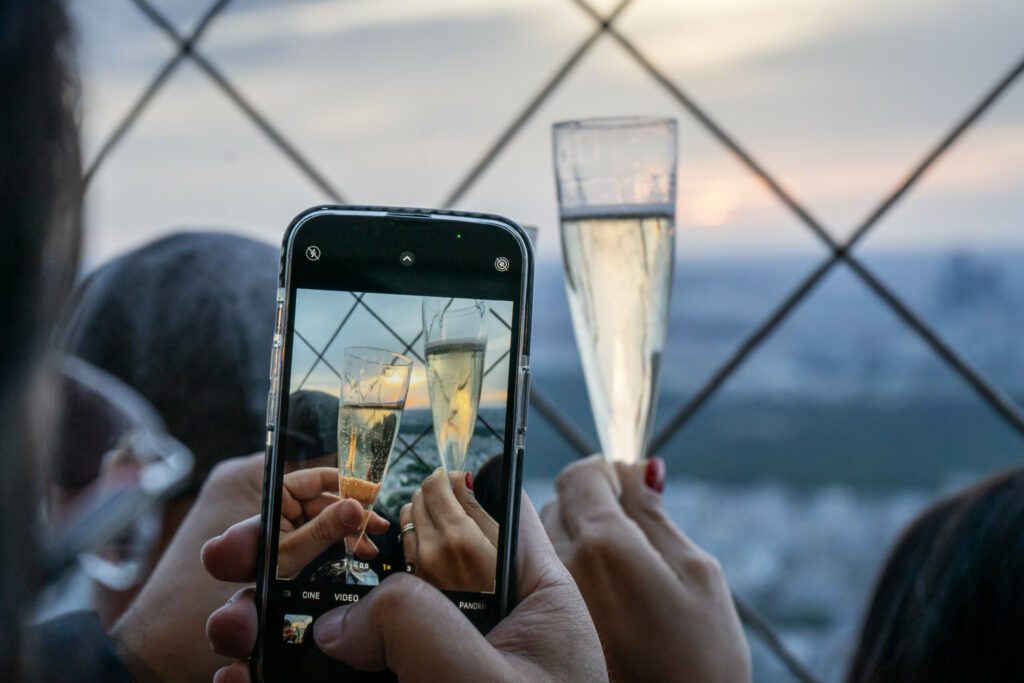person photographing champagne on Eiffel tower