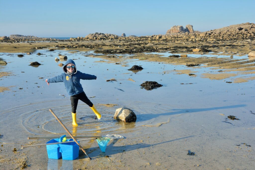 Un petit garçon qui pêche à pieds l'hiver en Bretagne