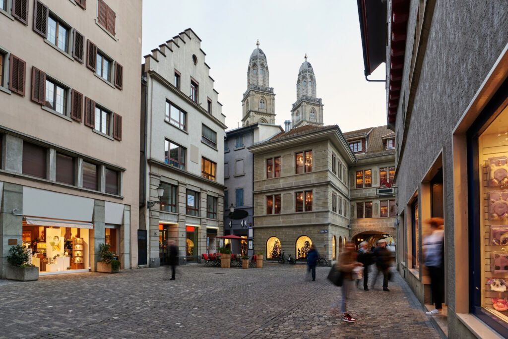 Stadt Zürich Altstadt Niederdorf Rüden-Platz Grossmünster Türme Abenddämmerung beleuchtete Schaufenster