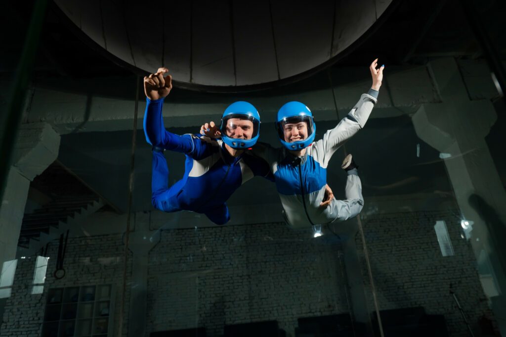 A man and a woman enjoy flying together in a wind tunnel. Free fall simulator