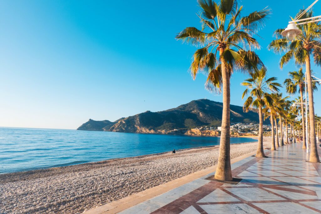 View to beautiful Albir town with main boulevard promenade, seaside beach and Mediterranean sea. Albir is small resort city between Altea and Benidorm, Alicante province, Spain