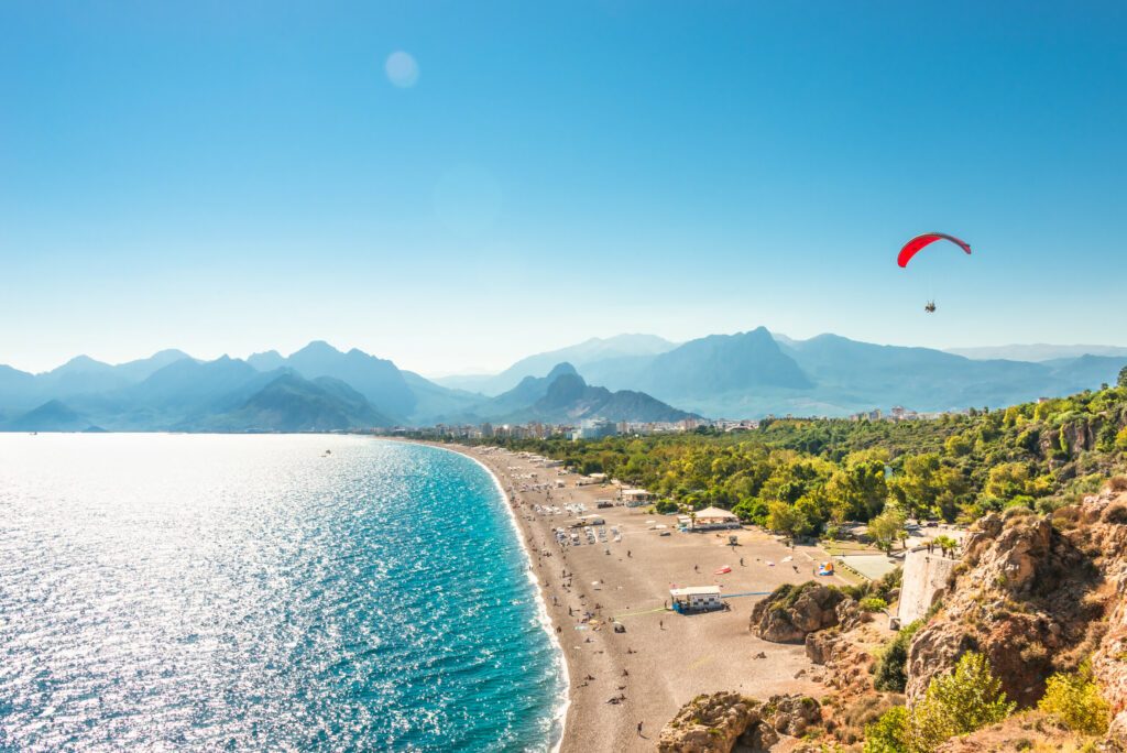 Panoramic bird view of Antalya and Mediterranean seacoast and beach with a paraglider, Antalya, Turkey