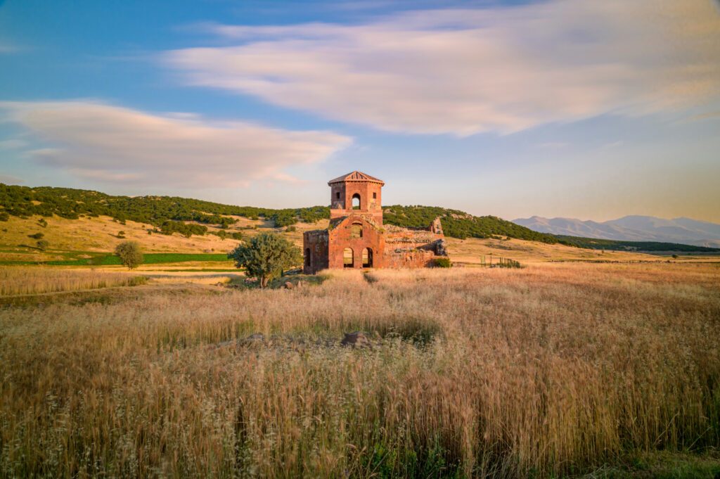 Red church ruins in Nigde province, sunset colors and clouds in the sky