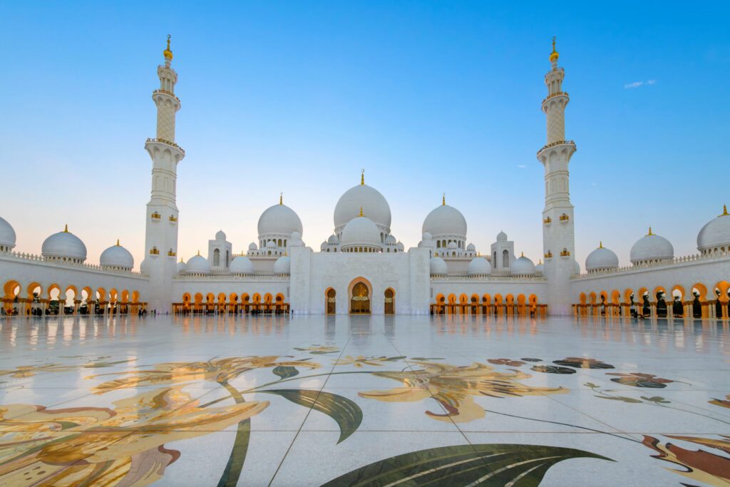 Interior courtyard of the Sheikh Zayed Grand Mosque, the largest mosque in the UAE, illuminated at twilight in Abu Dhabi, United Arab Emirates.