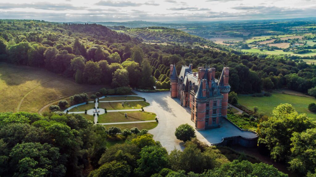 Aerial view of the Castle of Trévarez in Brittany, France - Red brick neo-gothic mansion built on a hillside in a beautiful domain with French classical gardens