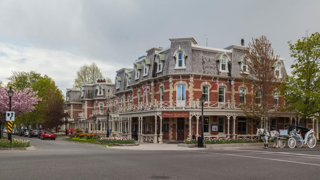 NIAGARA ON THE LAKE, ONTARIO, CANADA - MAY 14, 2017: Prince of Wales Hotel with horse carriage in Niagara On The Lake. Built in 1864, this three story hotel with 100 rooms is a landmark hotel .