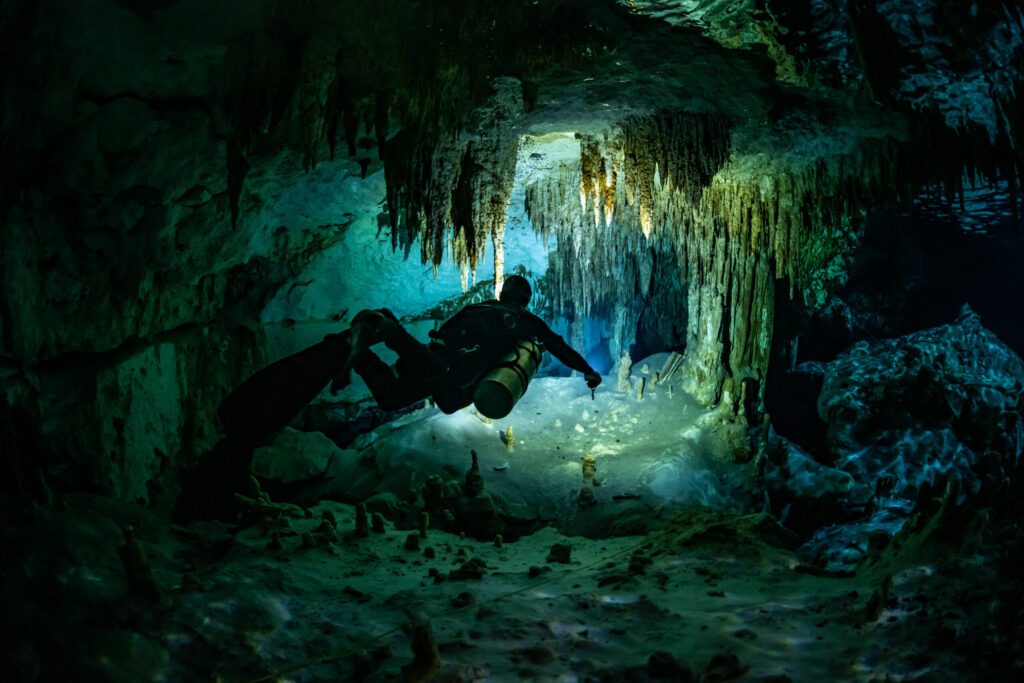 cave diver instructor leading a group of divers in a mexican cenote underwater