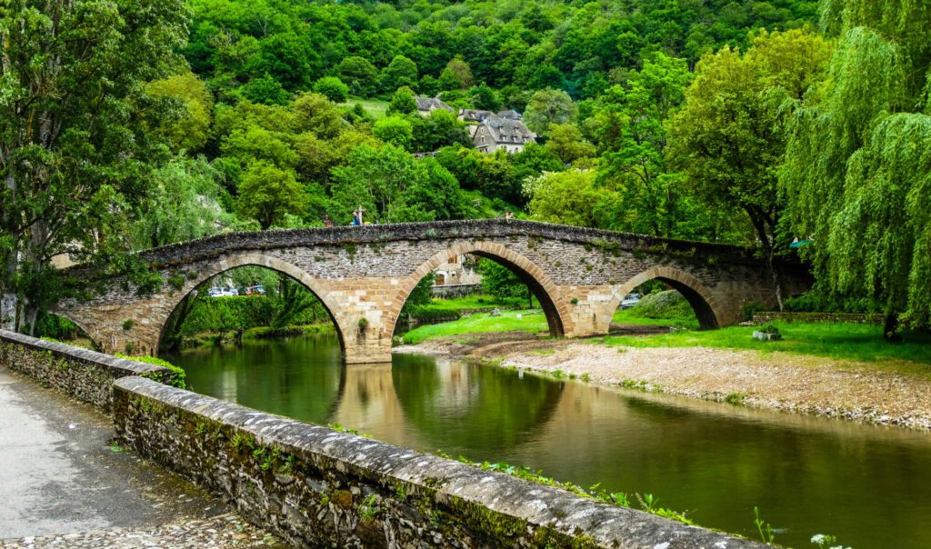 Belcastel medieval bridge with Aveyron river and green forest background , Aveyron, France