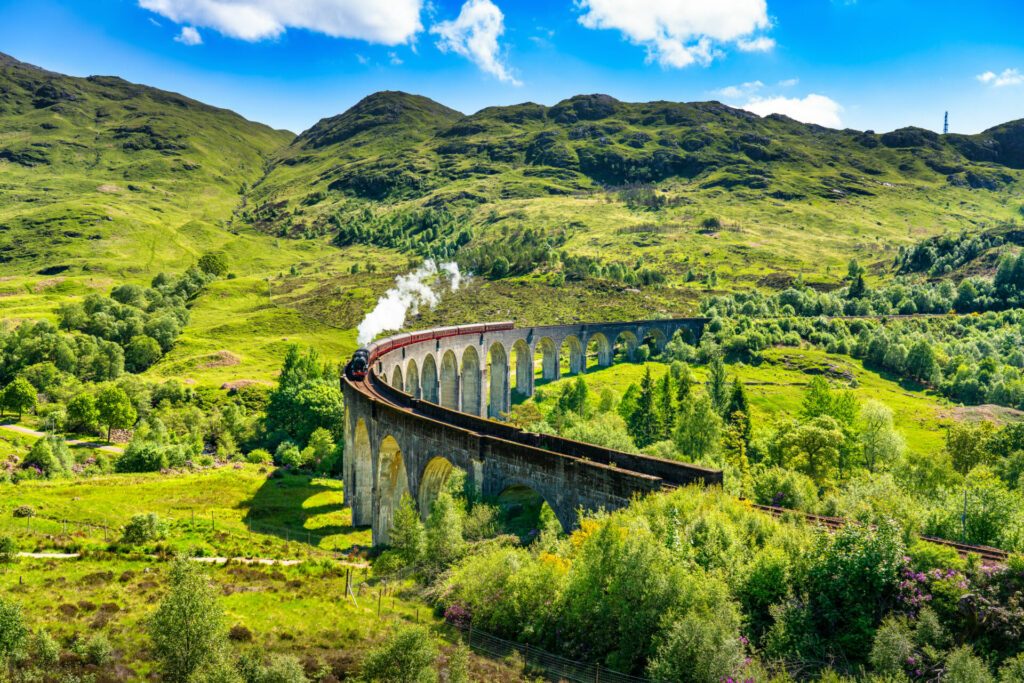 Glenfinnan Railway Viaduct in Scotland with the steam train passing over