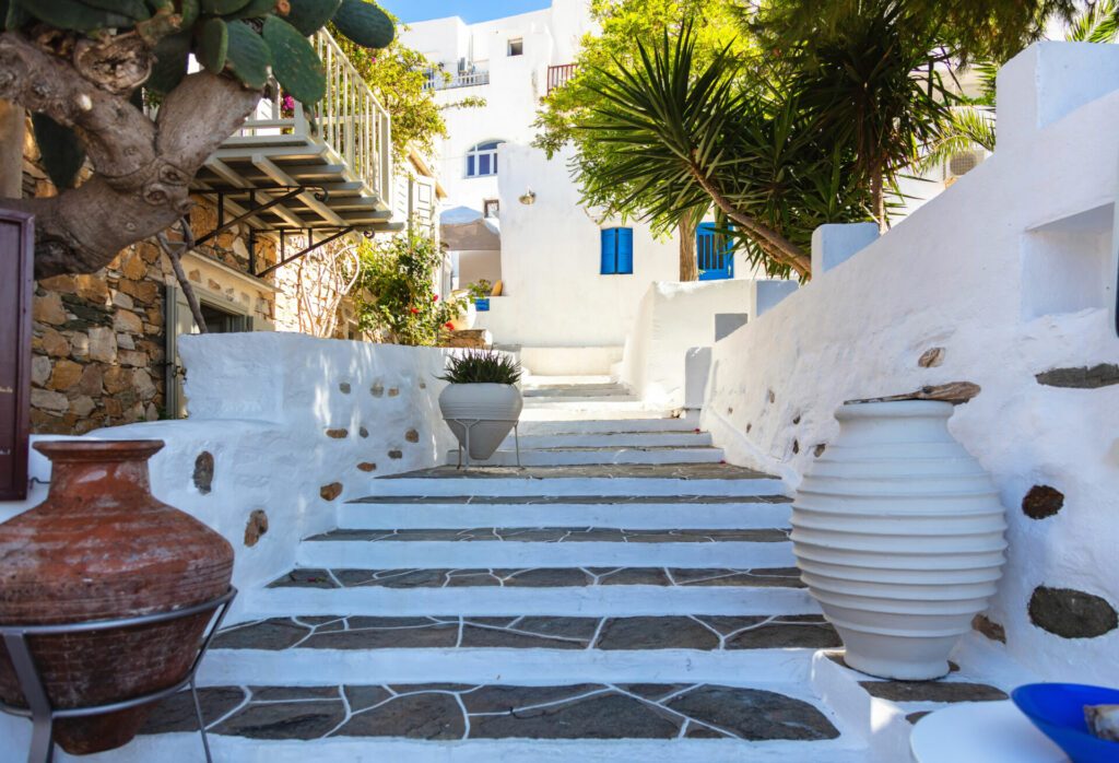 Houses whitewashed walls sunny day at Sifnos island, Greece. Stone stairs background.