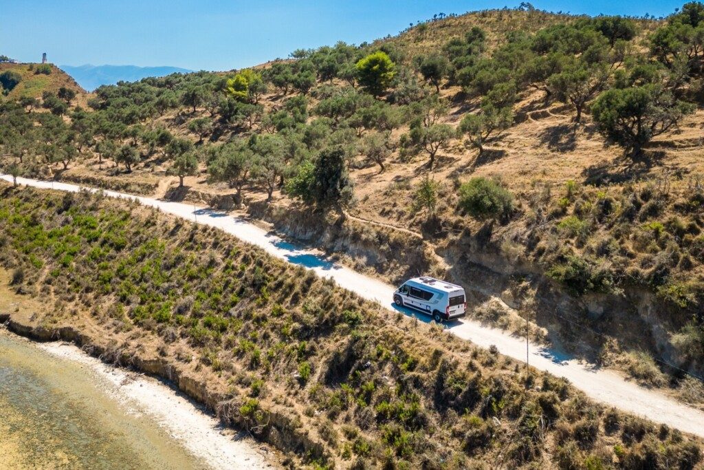 Road trip en fourgon aménagé sur petite route de graviers